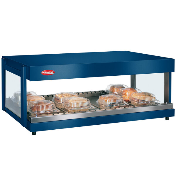 A navy blue Hatco countertop food warmer with bread on shelves in a bakery display.
