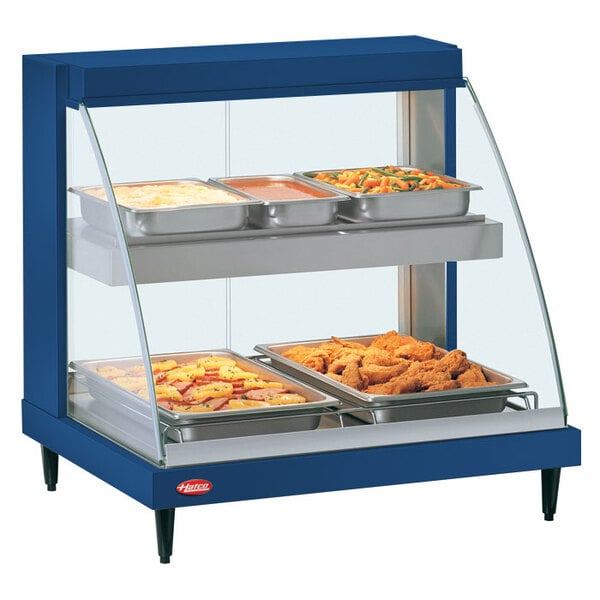 A navy blue Hatco countertop double shelf food warmer display case with trays of food inside.