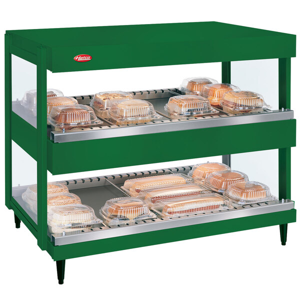 A green Hatco countertop with trays of food.