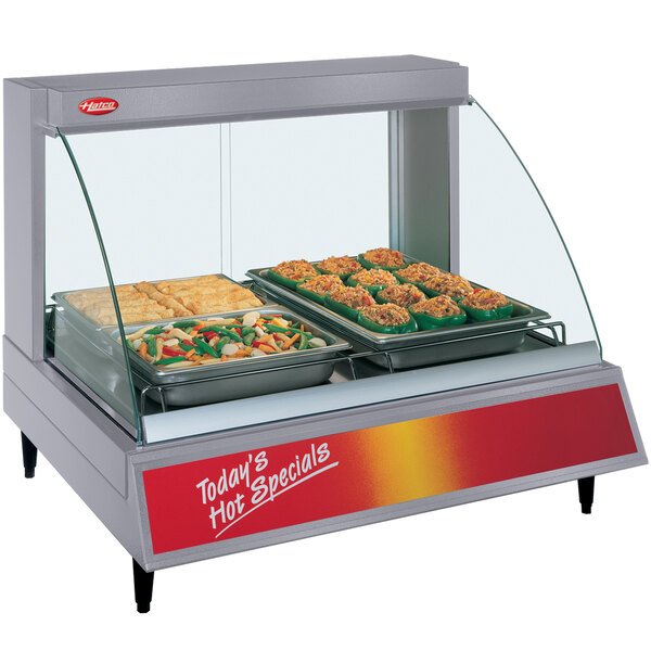 A Hatco countertop food warmer with a tray of stuffed peppers on display.
