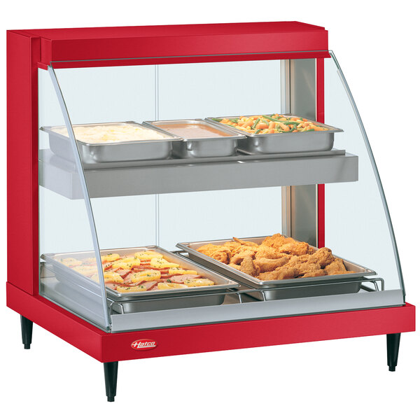 A red Hatco countertop food warmer display with two shelves of food.