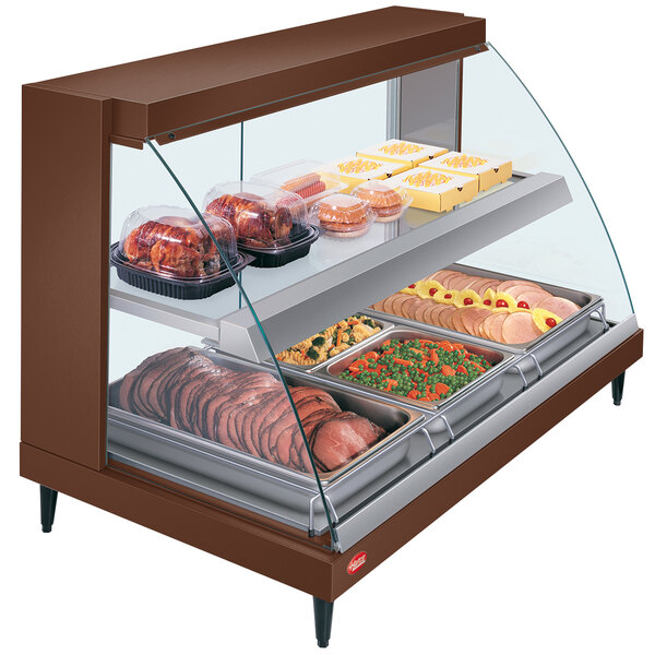 A Hatco countertop food warmer display with food on shelves.