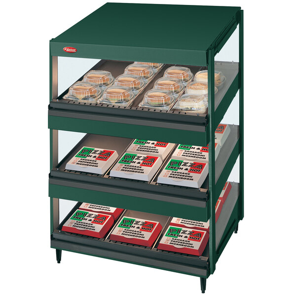 A Hatco green slanted countertop shelf with food on it.
