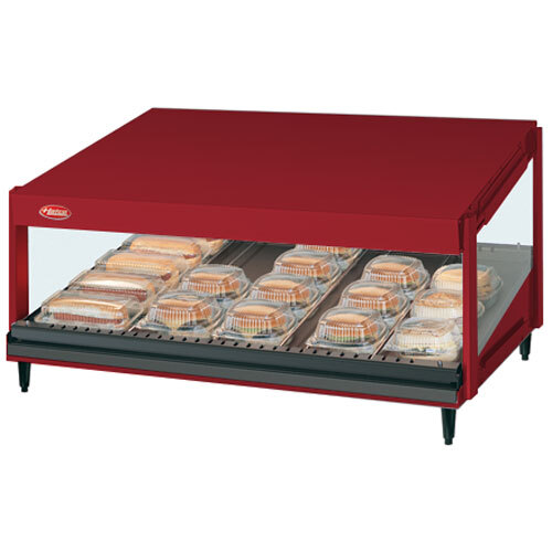 A red Hatco countertop food warmer with food on a slanted shelf.
