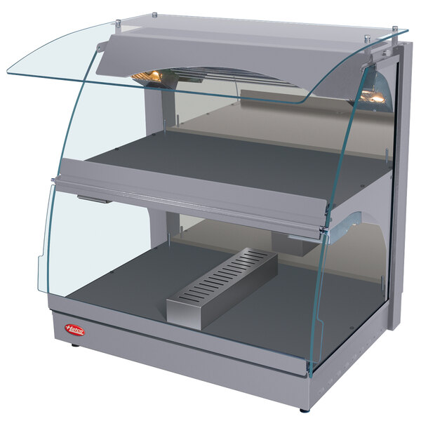 A silver Hatco countertop food warmer with curved glass shelves.