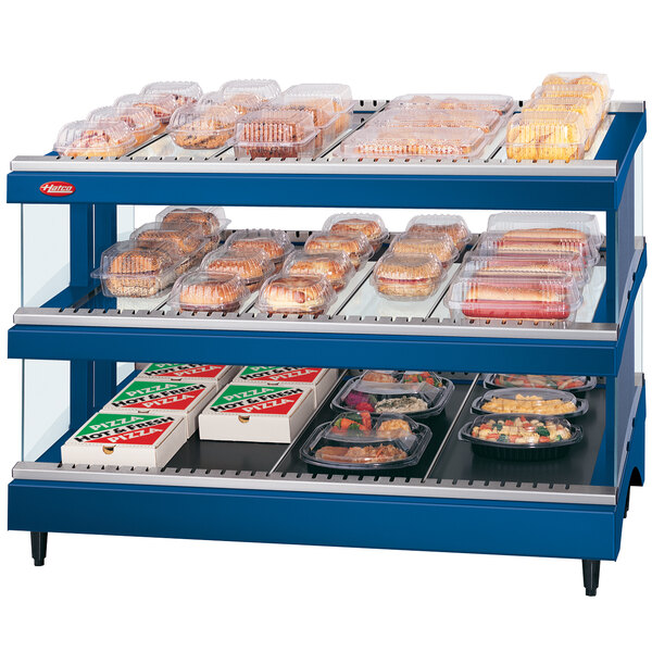 A navy blue Hatco food display warmer with shelves of food on a counter.