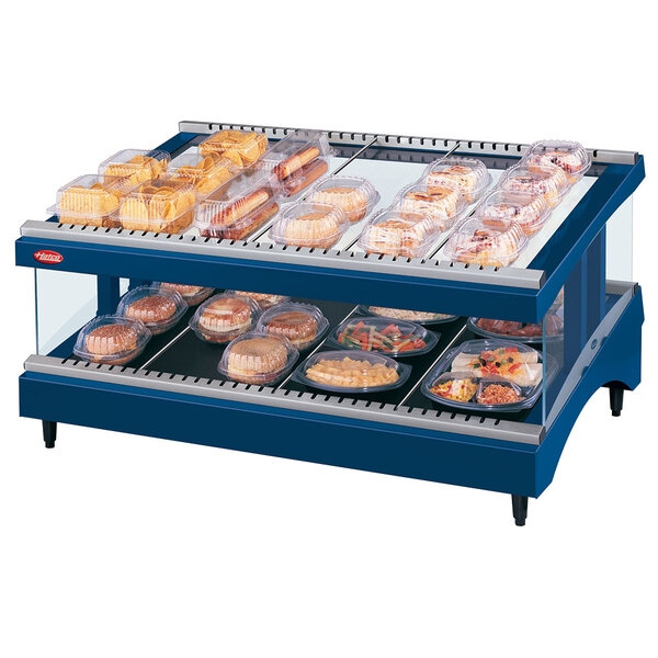 A Hatco navy blue heated glass shelf holding food on a bakery display shelf.