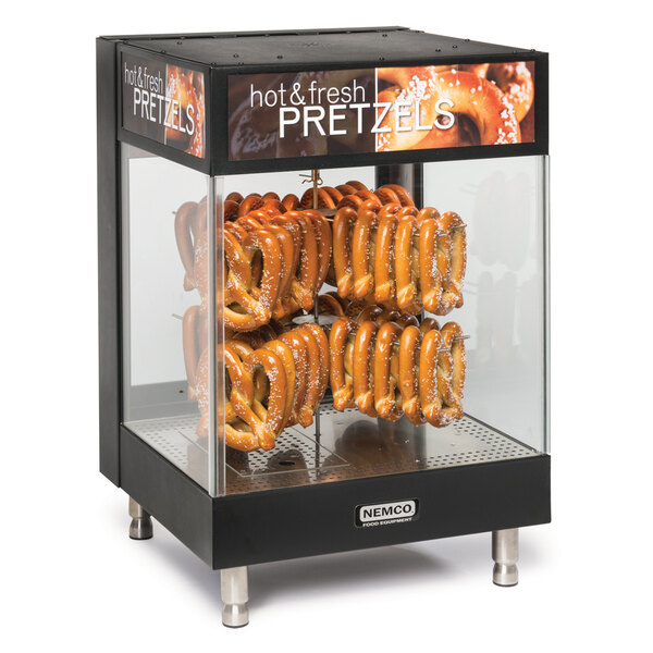 A Nemco countertop pretzel merchandiser with pretzels in a glass display case.