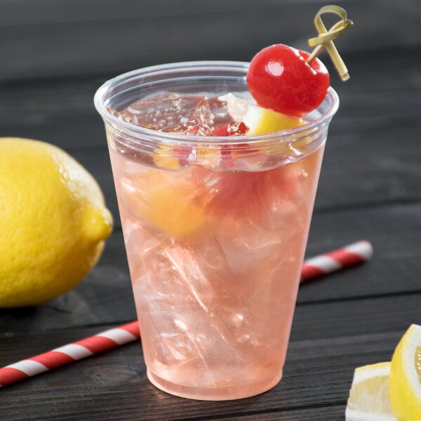 A Solo Ultra Clear PET plastic cup with a pink drink, a cherry, and a straw.