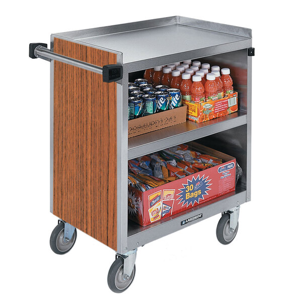 A Lakeside stainless steel utility cart with an enclosed base and drinks and snacks on it.