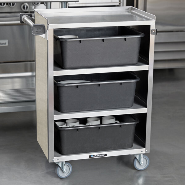 A stainless steel Lakeside utility cart with black containers on the shelves.
