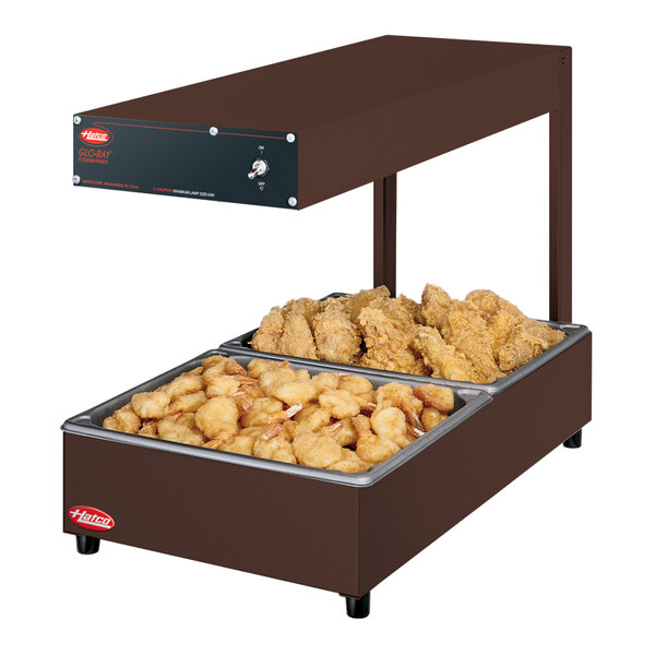 A Hatco portable food warmer with fried chicken and fries on a tray.
