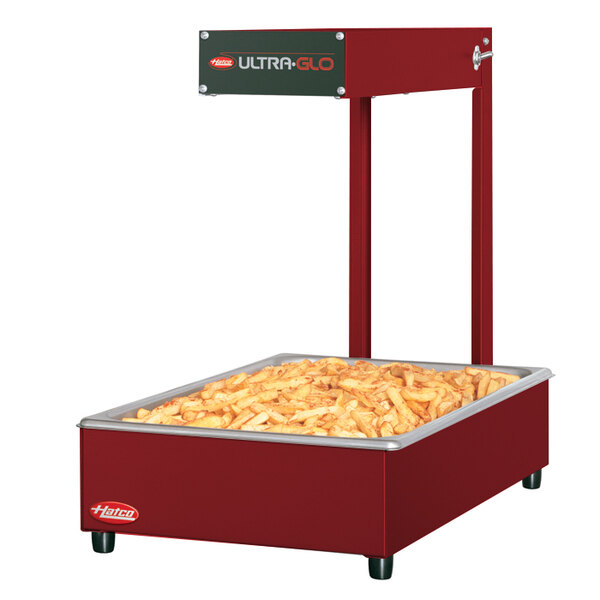 A red Hatco food warmer with french fries on top.