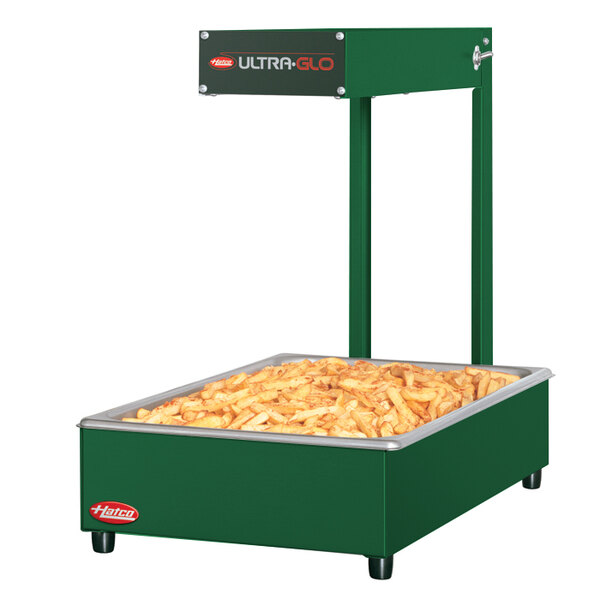 A large rectangular green Hatco food warmer with french fries inside.