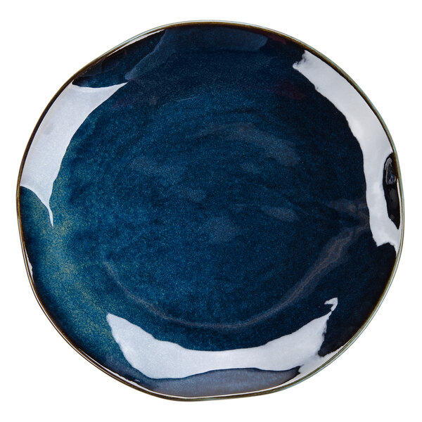 A Tuxton Artisan china plate with a white rim and a night sky design in blue and black.
