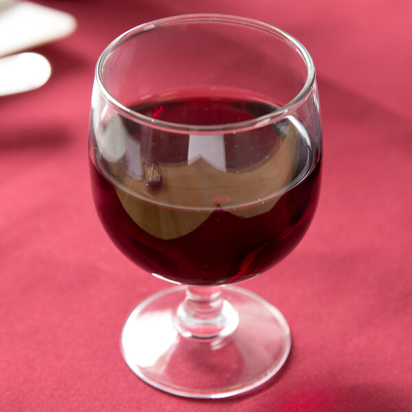 An Arcoroc Amelia stacking goblet filled with red wine on a table.