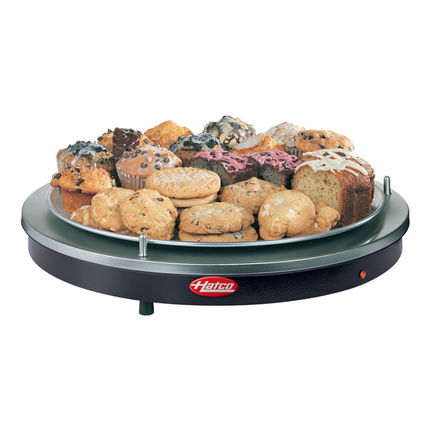 A table with a Hatco black heated shelf filled with a variety of baked goods.