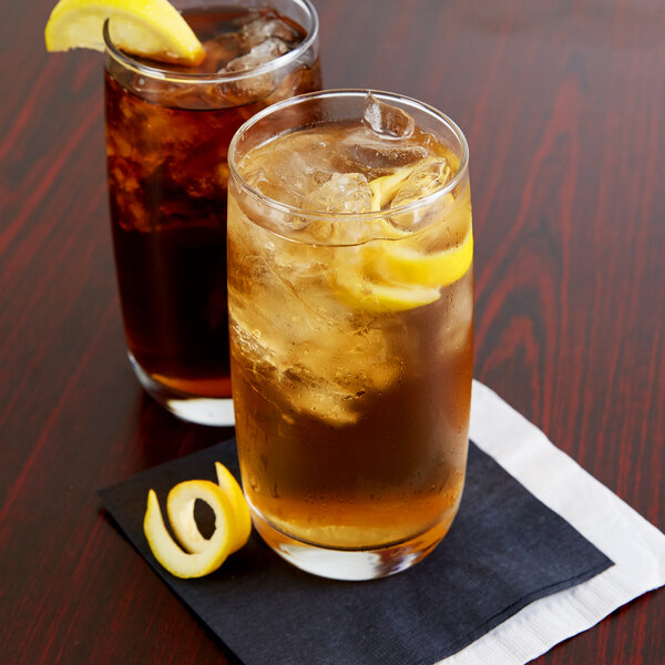 Two Arcoroc Cabernet glasses of iced tea with lemon wedges.