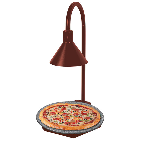 A pizza on a Hatco heated stone shelf with a display lamp.