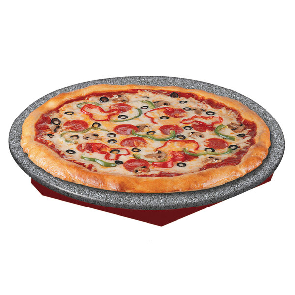 A pizza on a plate on a red and gray heated stone shelf.