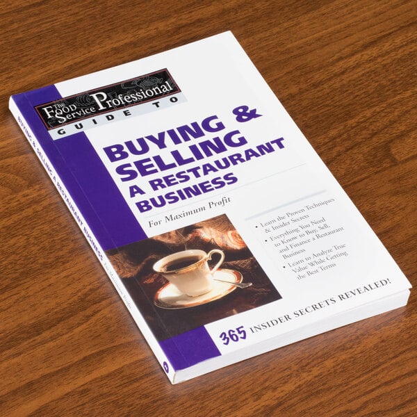 A book titled "Buying & Selling a Restaurant Business" on a table.