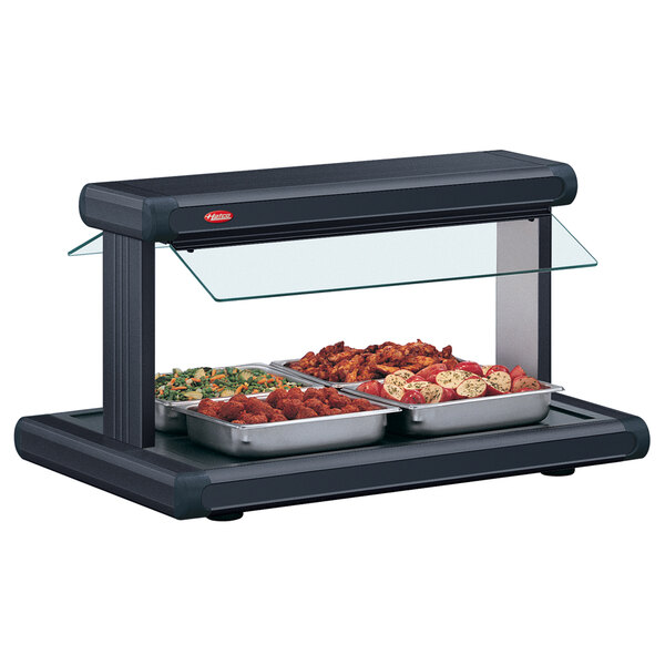 A black Hatco buffet warmer with black insets holding trays of food on a countertop.