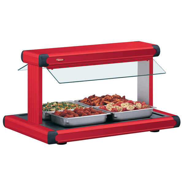 A Hatco red countertop buffet warmer with red food insets full of food.