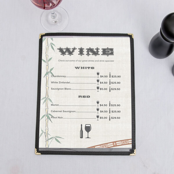 An 8 1/2" x 11" menu with a bamboo design on a table with a glass of wine.