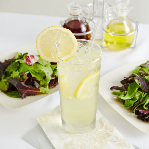 A glass of lemonade with ice and a lemon slice.
