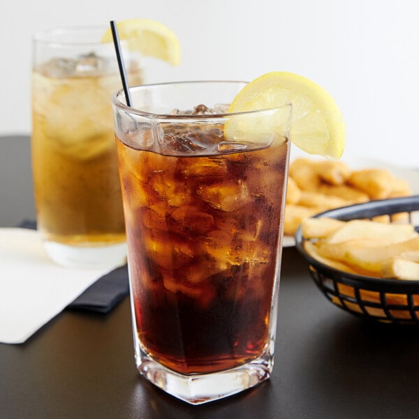 A glass of ice tea with lemon wedges on the rim.