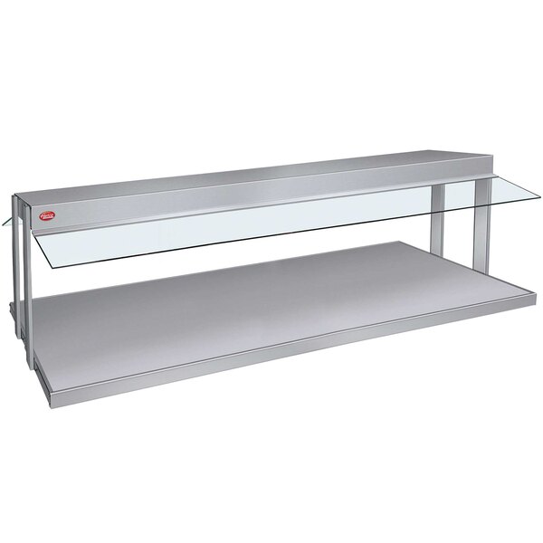 A silver Hatco buffet warmer with glass shelves on a stainless steel shelf.