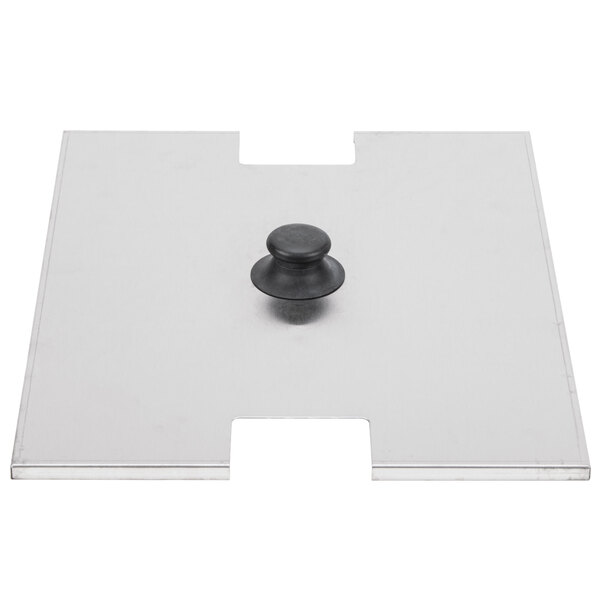 A white rectangular cover with a black button on a metal plate.