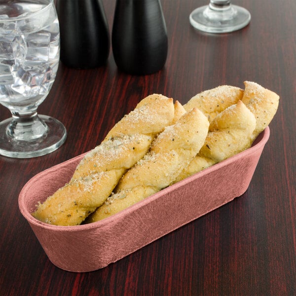 A black HS Inc. breadstick basket on a table with bread and glasses of water.