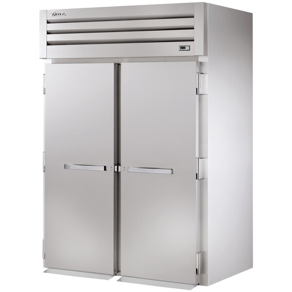 A large stainless steel True 2 section roll-in refrigerator with solid doors.