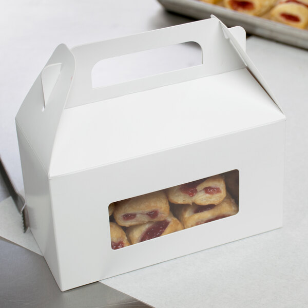 A white rectangular candy box with a window and food inside.