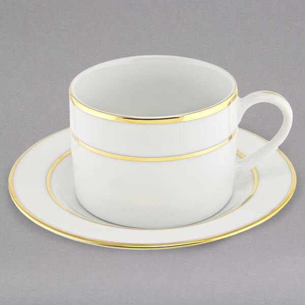 A 10 Strawberry Street white porcelain can cup and saucer with gold lines.