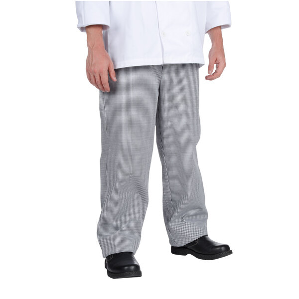 A person wearing a white chef coat and grey houndstooth pants.