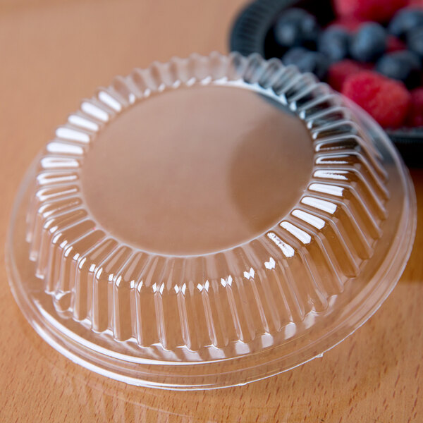 A Dart plastic container lid on a bowl of berries.