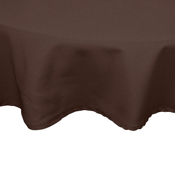 A brown Intedge round poly/cotton table cover on a table.