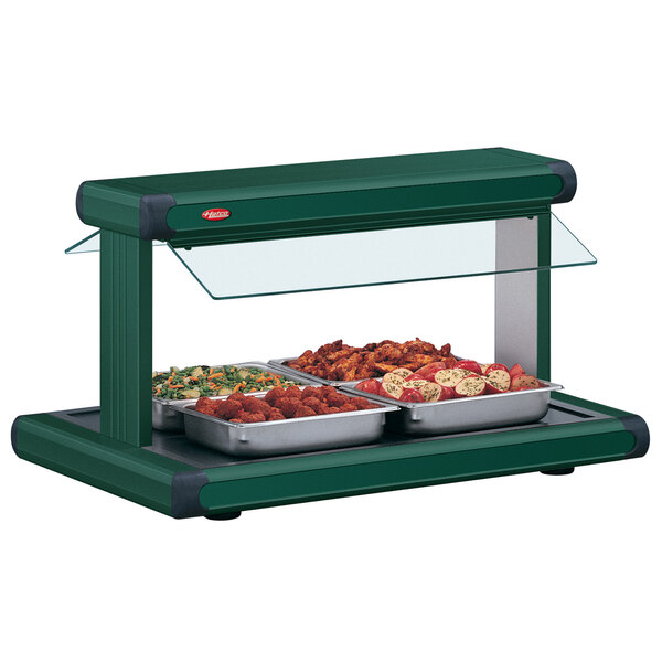 A Hatco buffet food warmer with green insets holding food on a table.