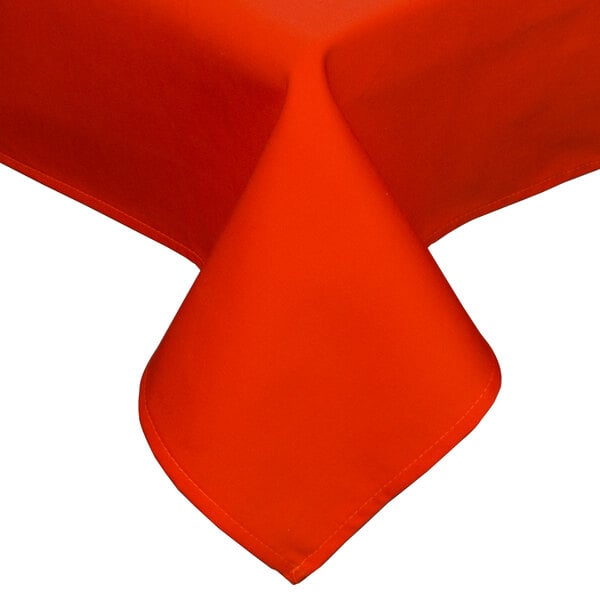 An orange Intedge rectangular table cover with a folded edge on a table.