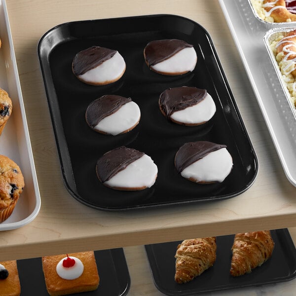 A black Cambro market tray with pastries and cookies on it.
