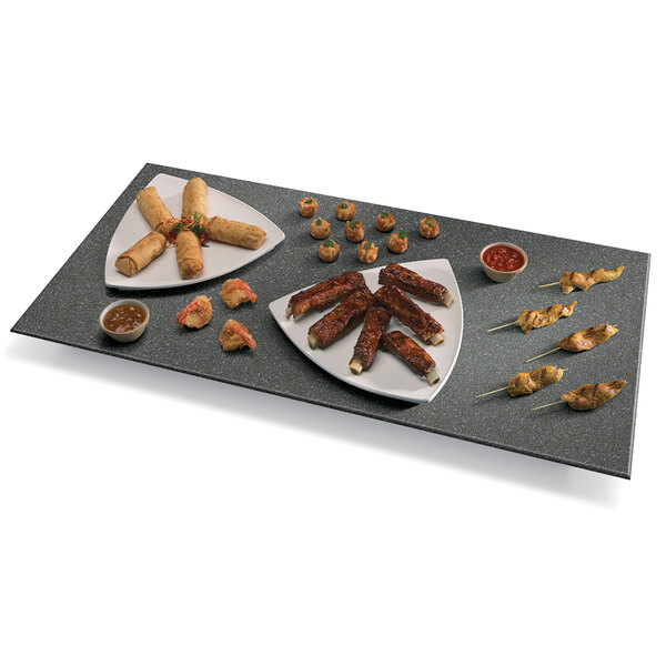 A Hatco heated stone shelf with a plate of ribs on a table.
