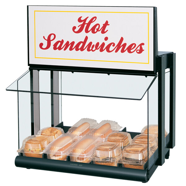 A Hatco countertop hot food display warmer holding hot sandwiches with a sign.
