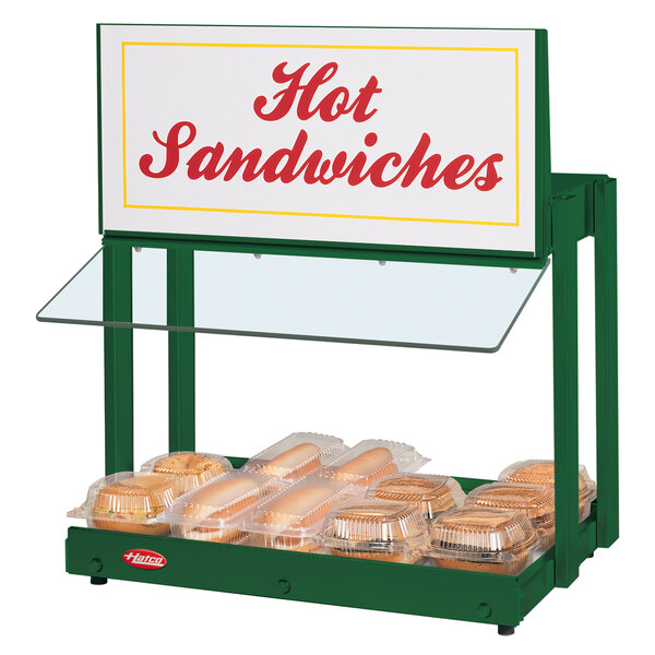 A Hatco mini-merchandising warmer with hot sandwiches and a sign.