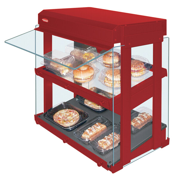 A red Hatco countertop food warmer with heated glass shelves displaying food.