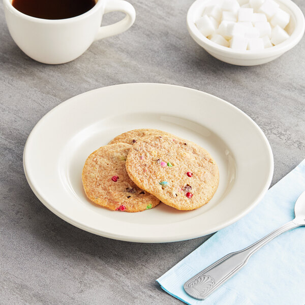 An Acopa ivory stoneware plate with cookies and a cup of coffee on it.