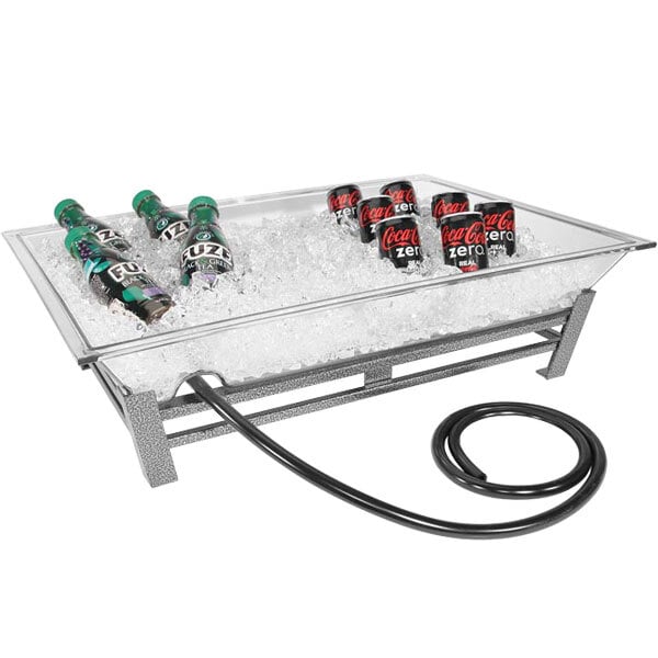 A Cal-Mil Ultimate Platinum Ice Housing system with soda bottles and cans in ice on a table outside.