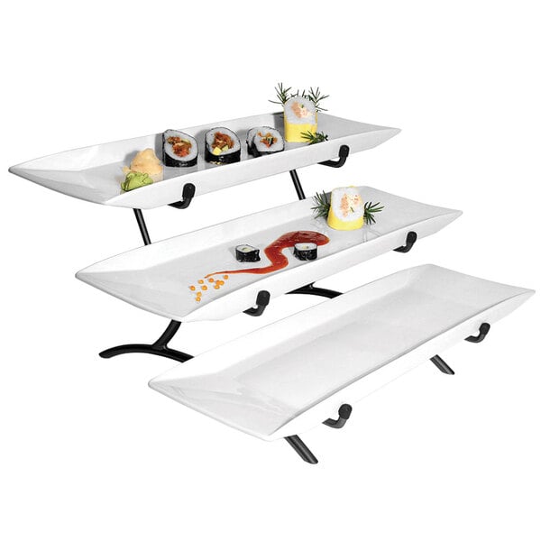 A Cal-Mil black wire stand with three white rectangular plates of sushi on it.
