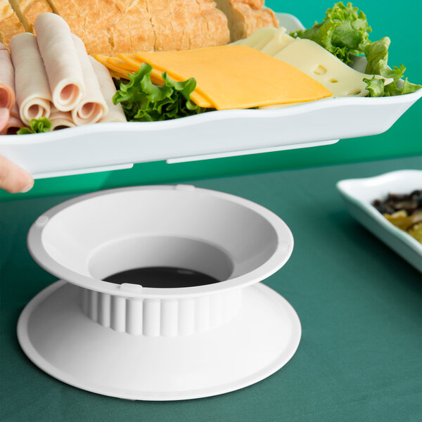 A white melamine pedestal holding a plate of food.